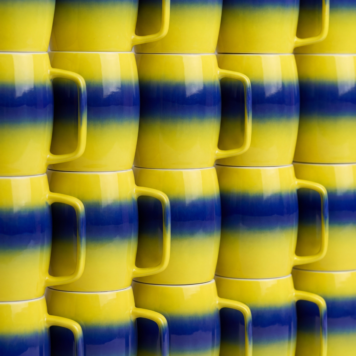 Stacks of yellow and blue ceramic mugs